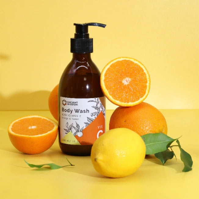 Detergente corpo alla Vitamina C circondato da arance e limoni freschi - Pleyas